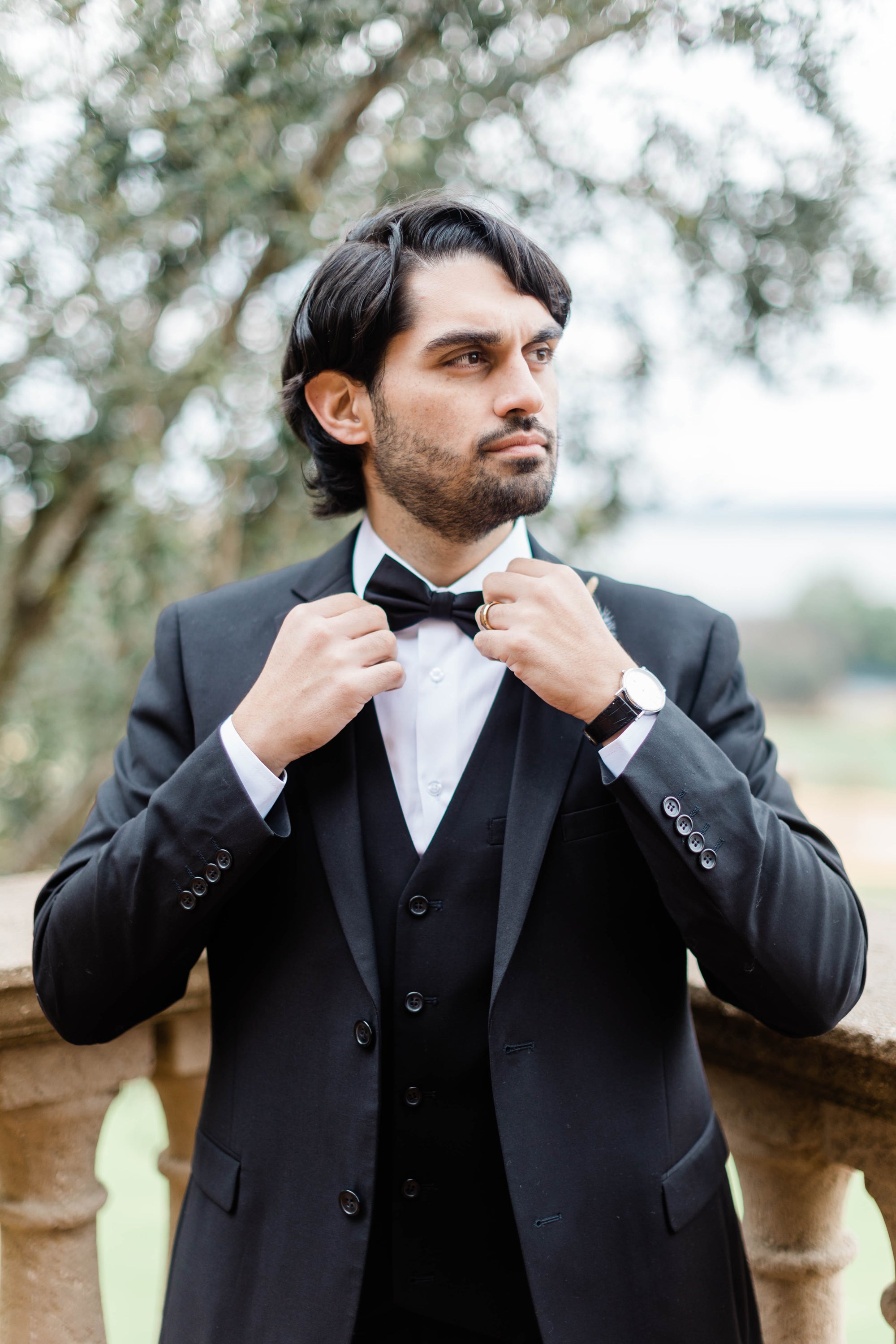  A man shows off the details of his holiday party suit and bow tie