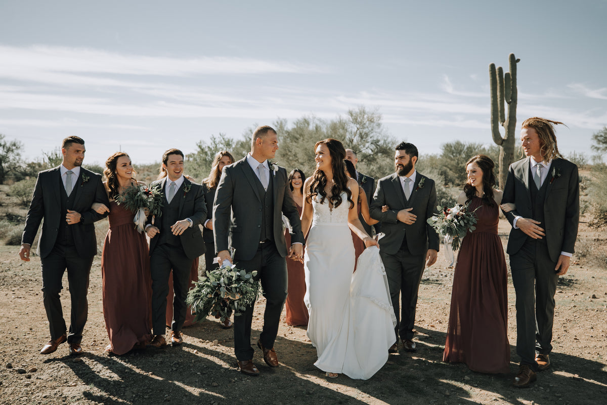 Wedding party walking together outdoors in formalwear.