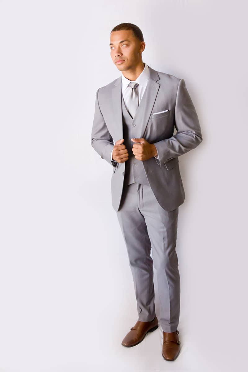 Man posing in a light grey modern groom suit.