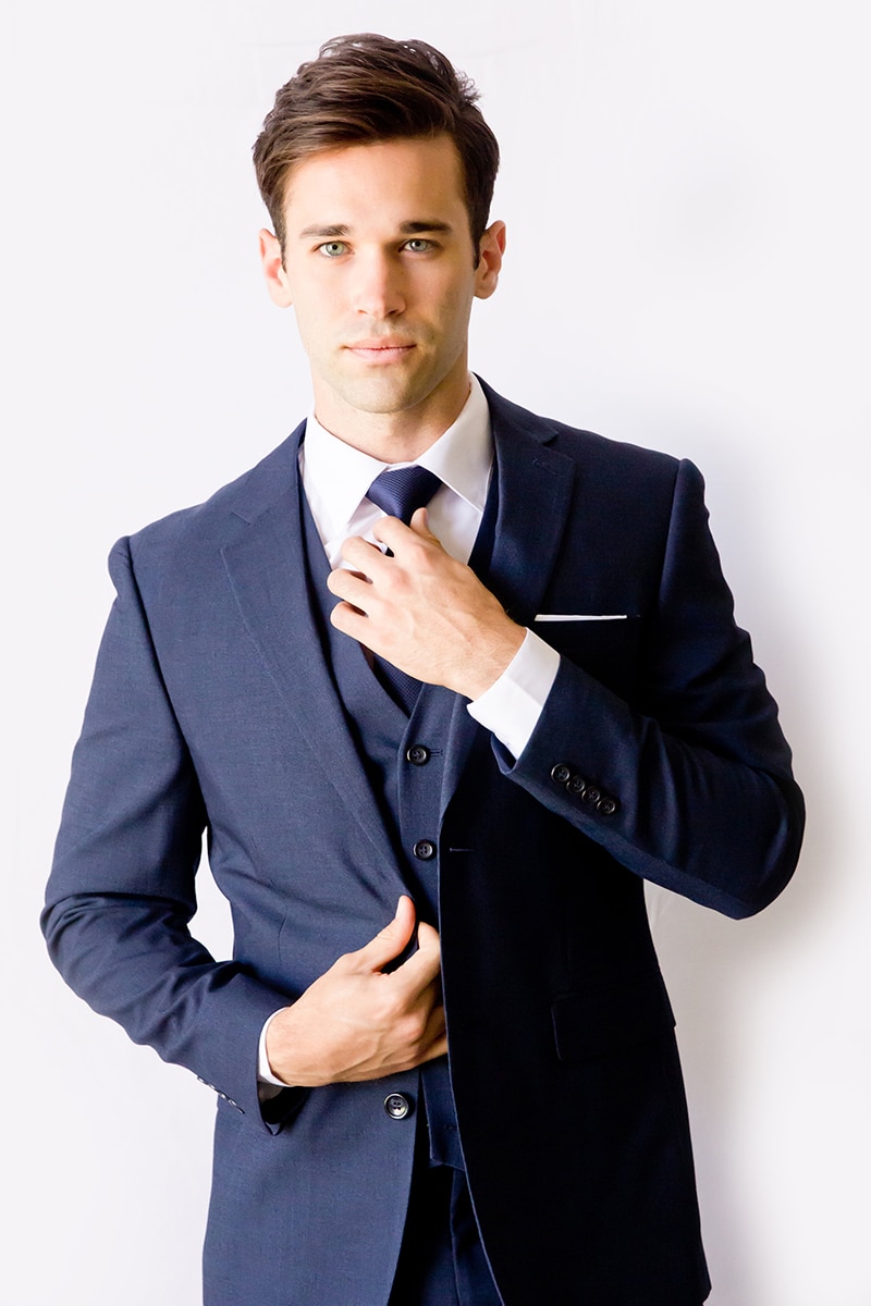 Man posing in a blue suit and tie.
