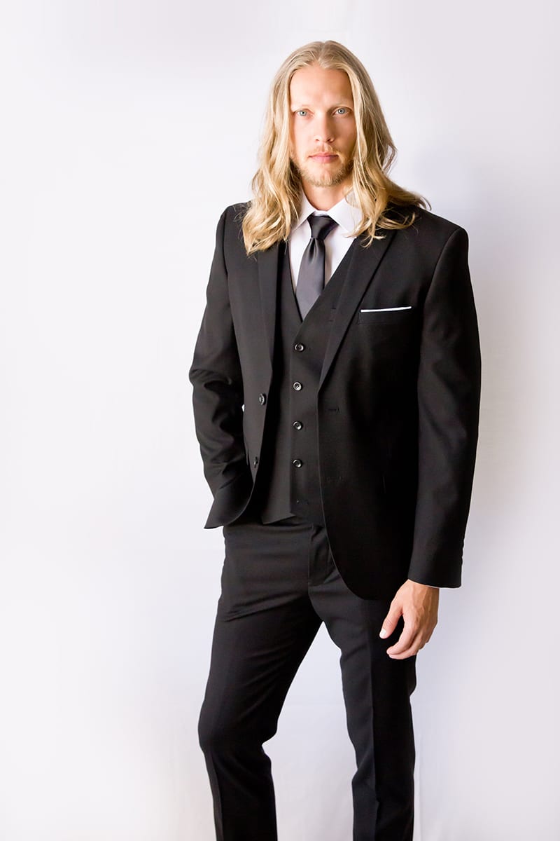 A male model in a black groom suit.