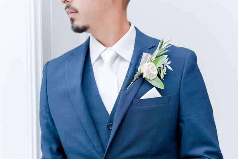 A featured blue suit with a boutonniere.
