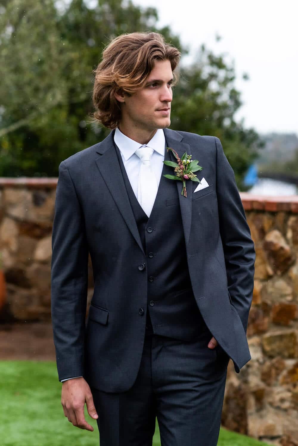 Young groom in Modern Groom attire with a scenic natural backdrop.