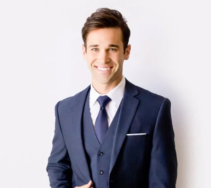 Cropped view of a young man in a blue wedding suit.