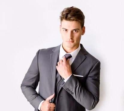 Cropped shot of a man in a gray wedding suit adjusting his tie.