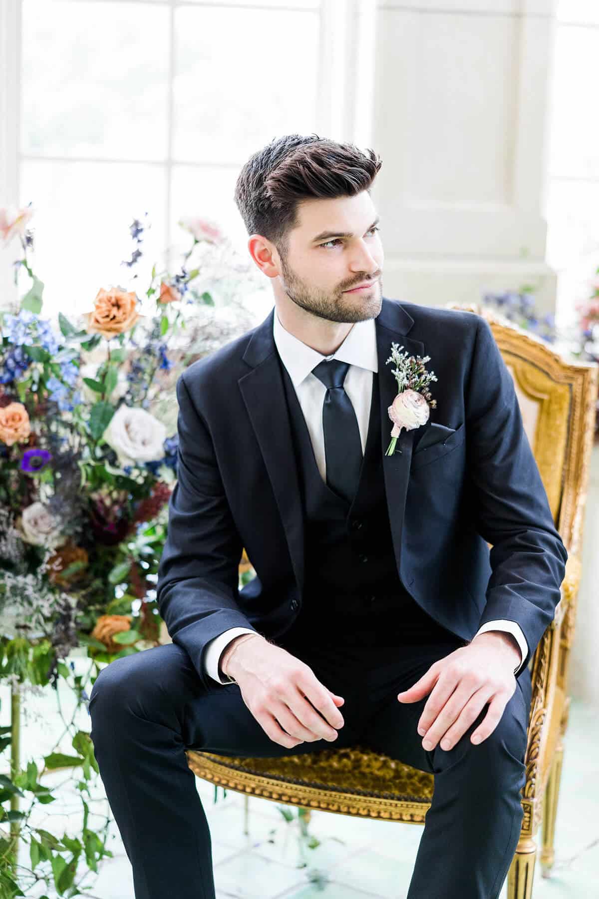 man in modern groom wedding suit sitting in a chair