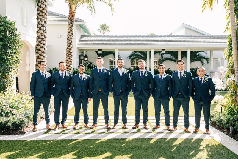 How to differentiate the groom from groomsmen with different ties outside on the grass