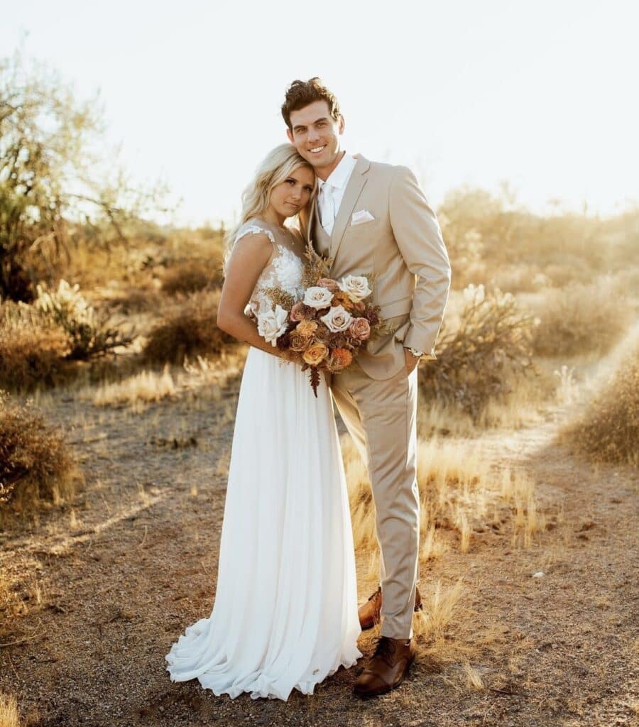 A man in a tan suit from The Modern Groom with his bride