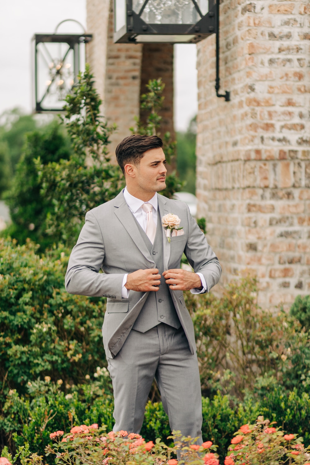 A close-up picture of a man in a light grey summer wedding suit