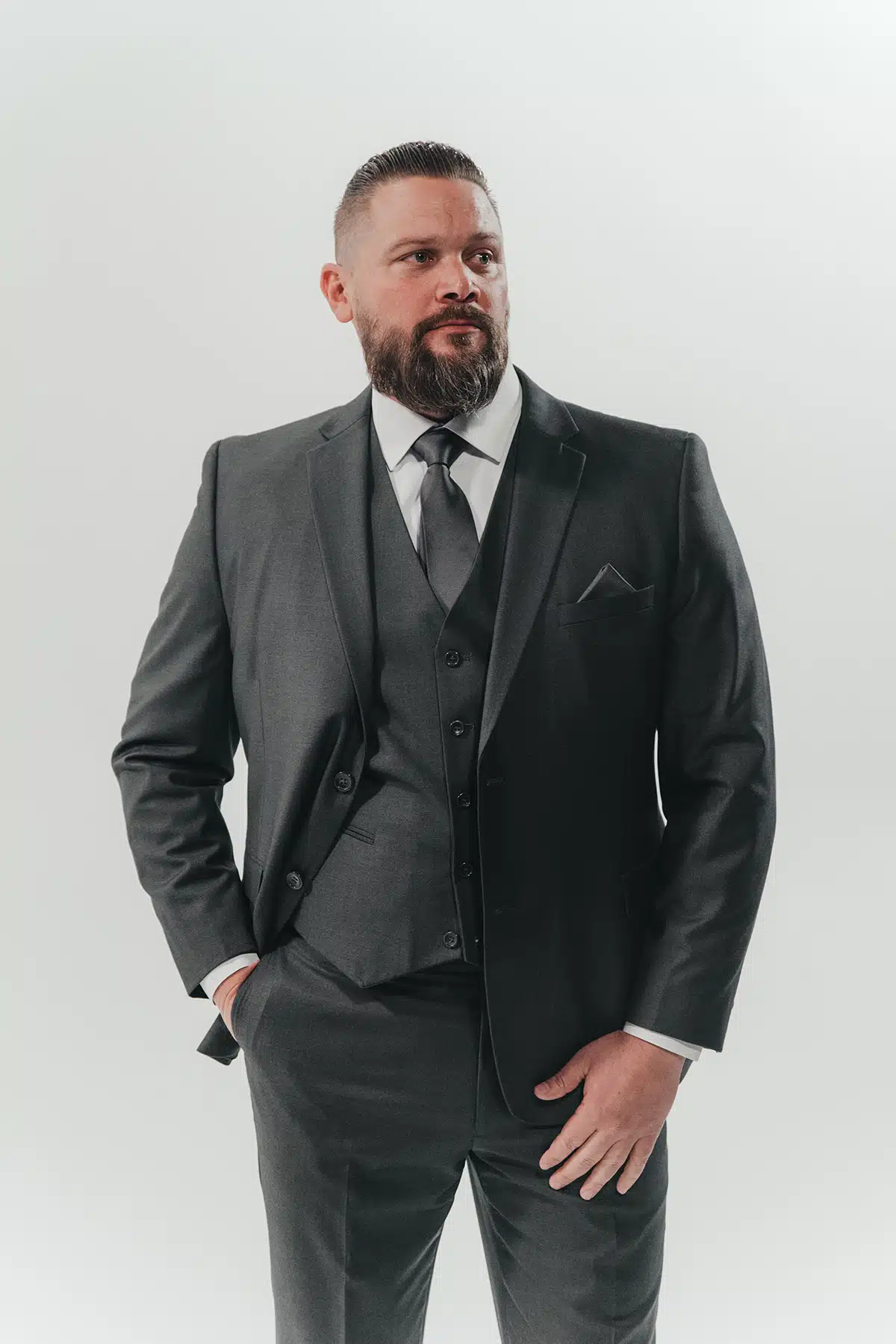 A man wearing a charcoal grey winter wedding suit 