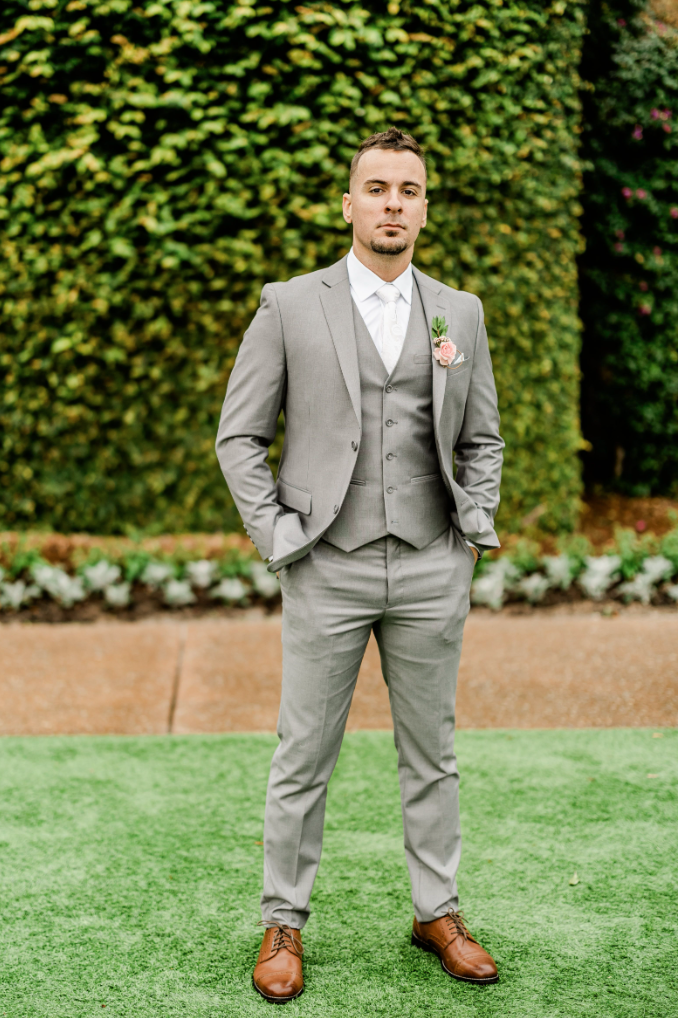 Groom wearing a light grey wedding suit and spring boutonniere