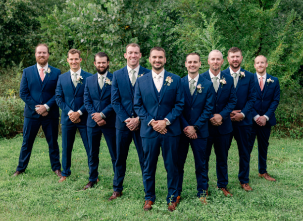 Groom and groomsmen posing in different suit fits