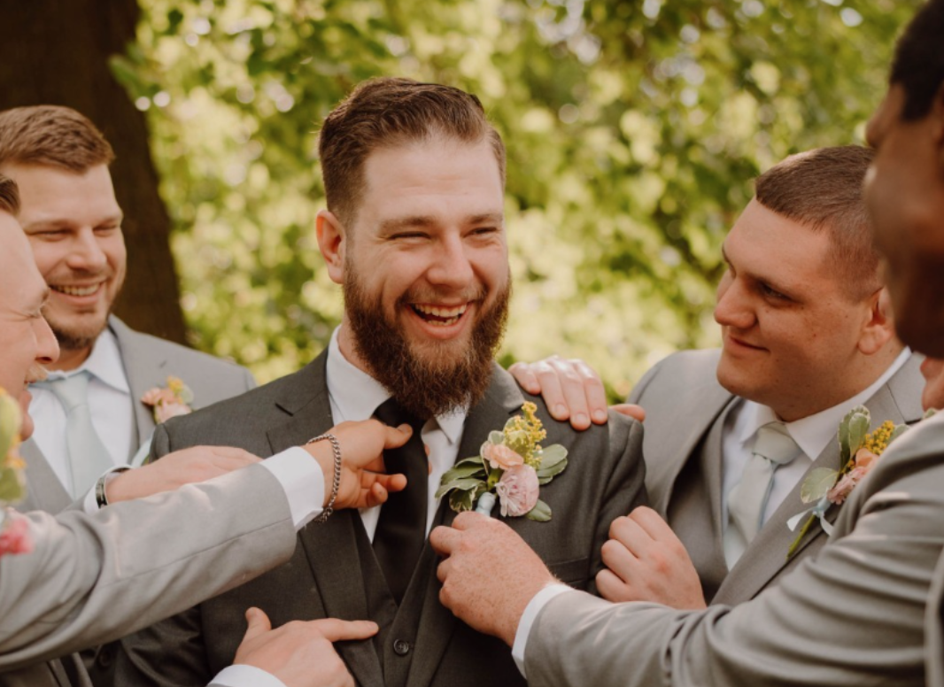 A groom and groomsmen wearing suits for larger men