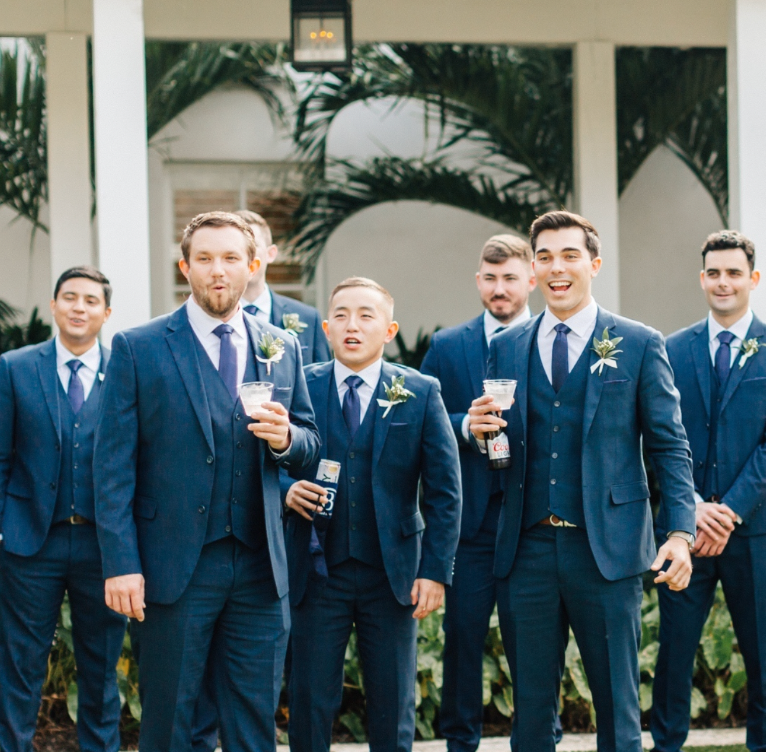 Groomsmen in varying sizes of blue wedding suits and some blue suits for shorter men