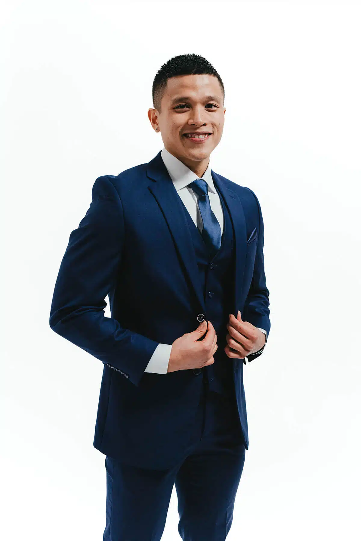 Smiling groom wearing a navy three-piece winter wedding suit