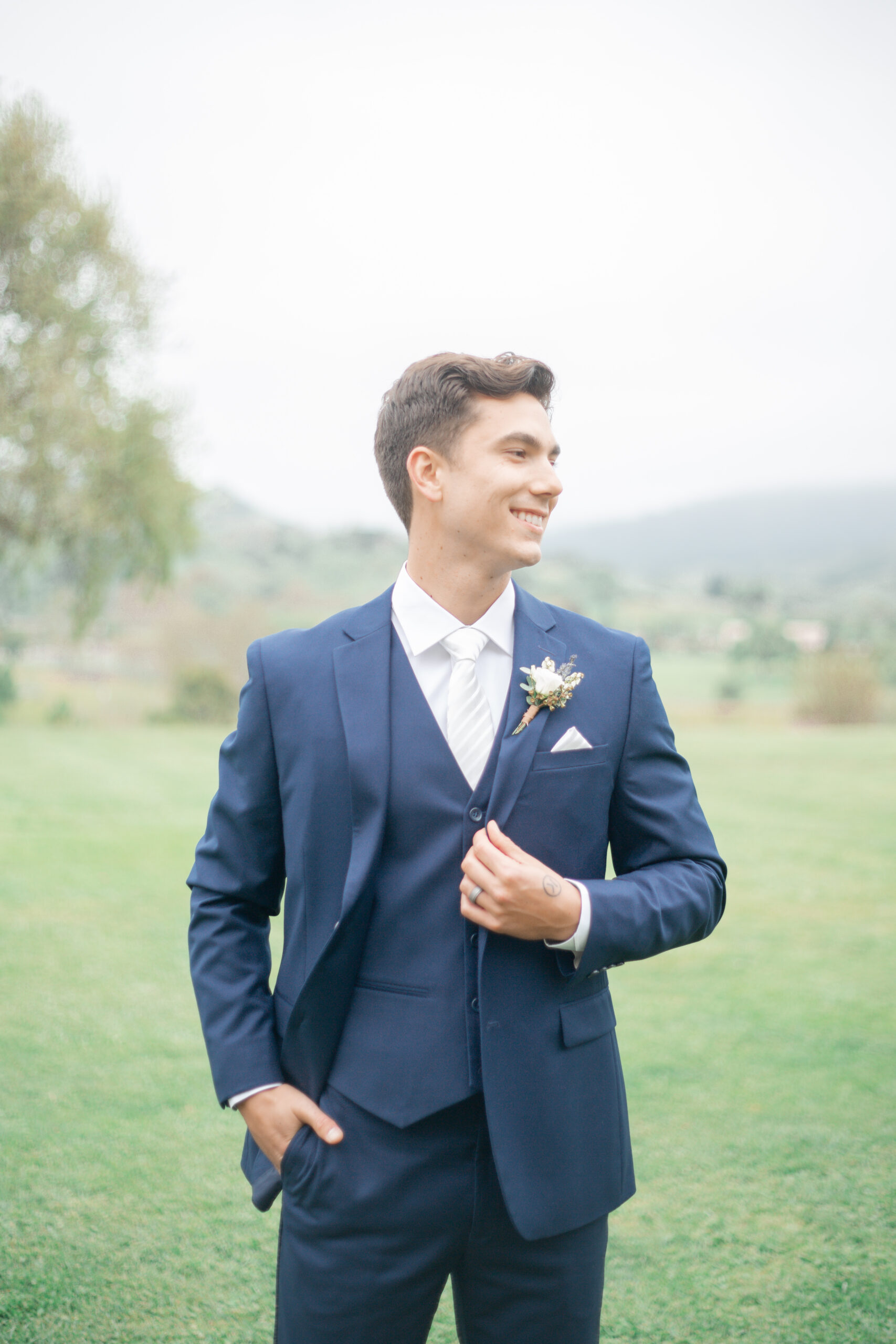 A groom wearing a three-piece midnight navy blue suit for his wedding day
