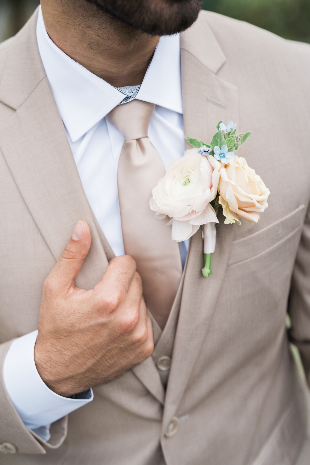 Close-up view of a tailored tan wedding suit fitting