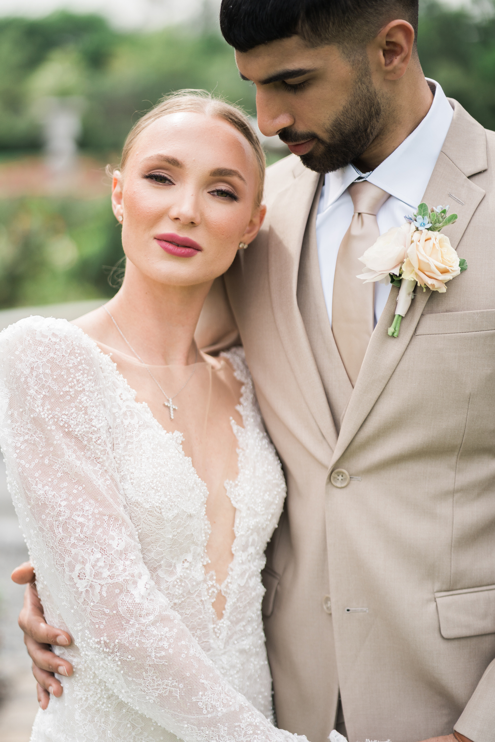 Groom in tan spring suit poses with bride