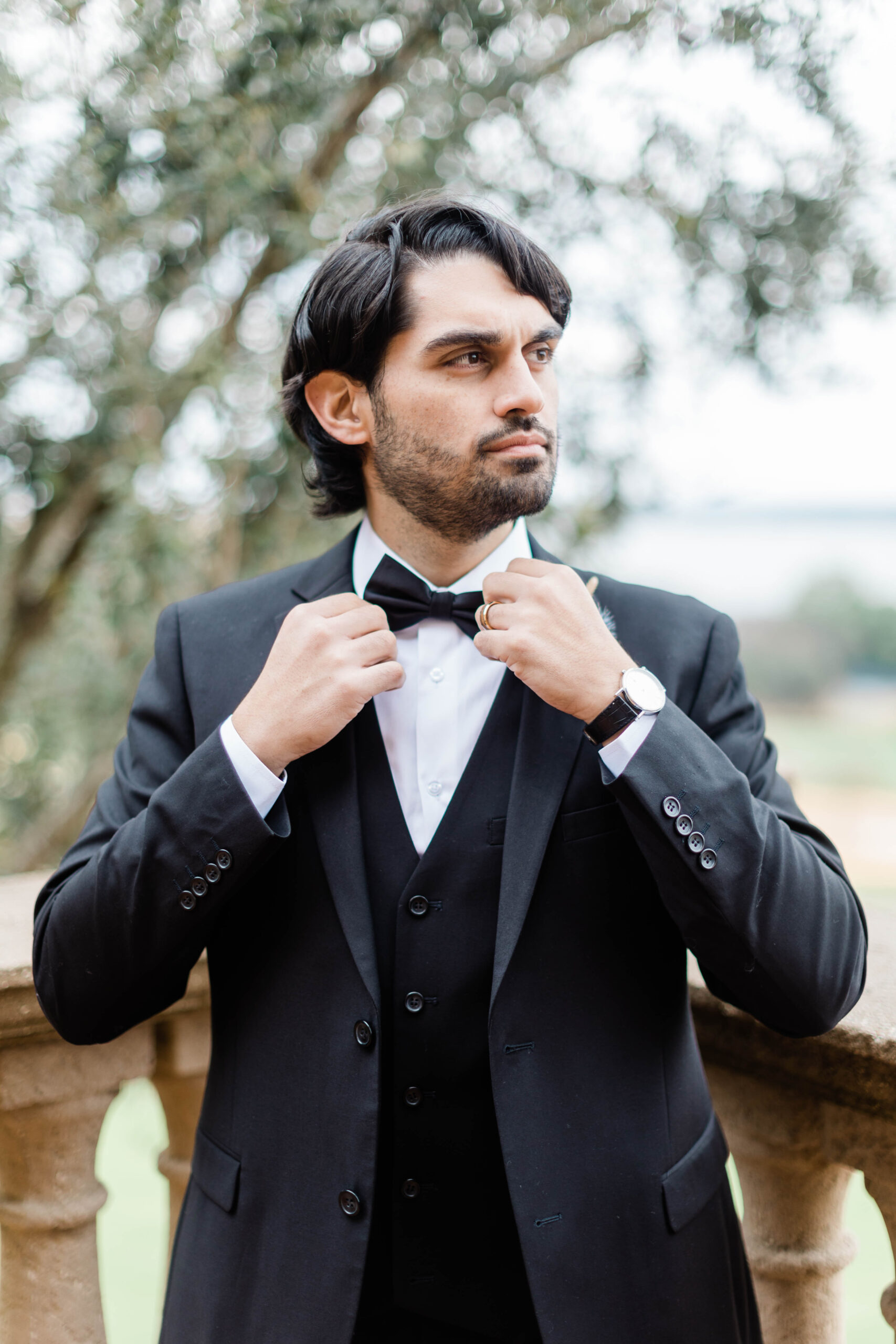 Man adjusting his bow tie showing off how to match your suit and ring